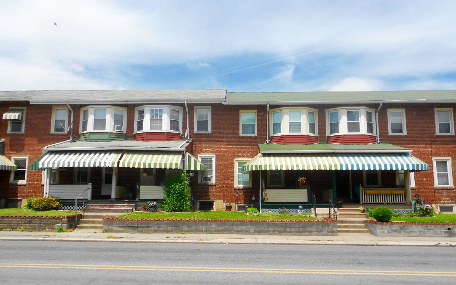 A row of houses with front porches along a residential street