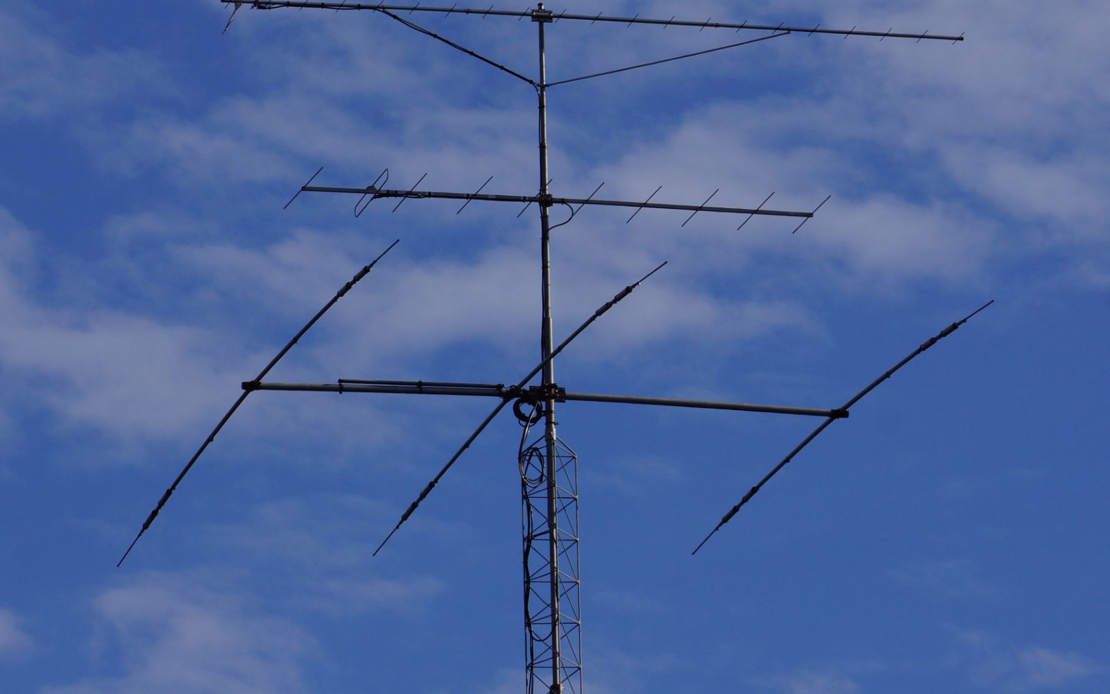 A directional amateur radio antenna against a blue sky