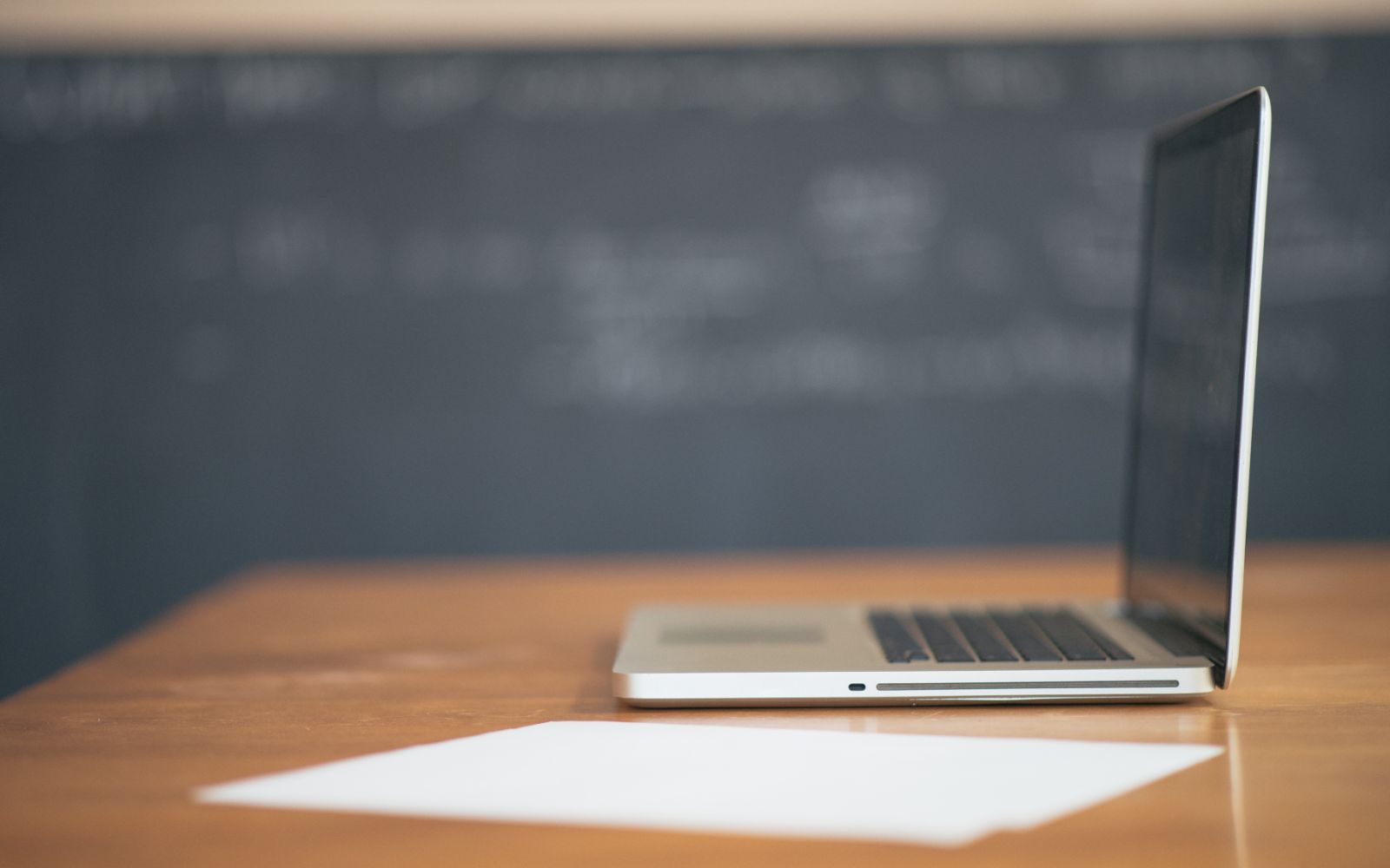 An open laptop on a wooden desk